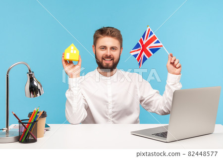 Emotional businessman working on laptop on blue background. Emotional businessman working on laptop on blue background. 82448577