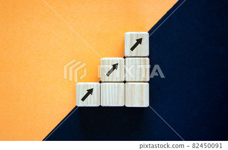 Business concept growth success process. Wood block with arrow signs stacking as step stair on paper peach and black background, copy space. Business concept growth success process. Wood block with arrow signs stacking as step stair on paper peach and black background, copy space. 82450091