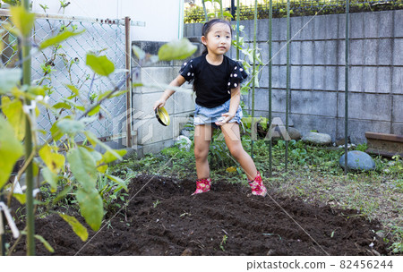 Girl enjoying the vegetable garden Girl enjoying the vegetable garden 82456244