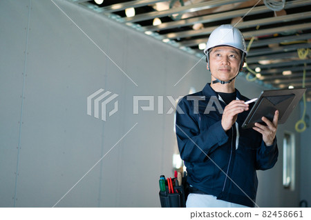 Male worker looking at a tablet 82458661