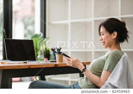 Happy asian woman using mobile phone at modern office 82459465