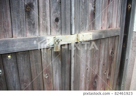 Lock attached to the bartack of an old wooden door Lock attached to the bartack of an old wooden door 82461923