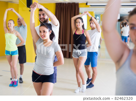 sporty girls and men learning salsa steps 82462320
