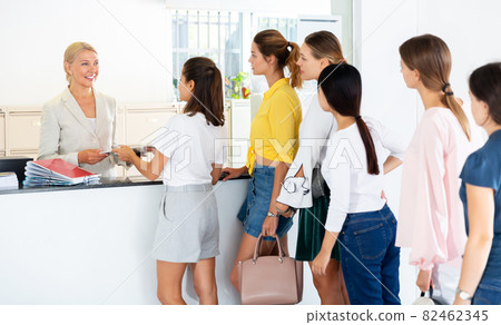 Students standing in line at reception desk 82462345