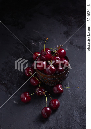 Organic juicy cherry in a bowl on dark background. Close-up photo, low key 82462448