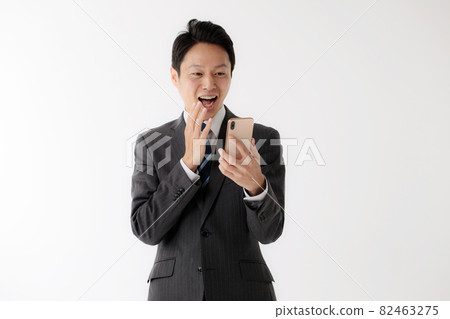 Businessman surprised smartphone middle man 82463275
