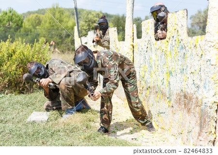 Female paintball player aiming in shootout Female paintball player aiming in shootout 82464833