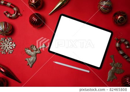 Red and gold Christmas decoration ball and digital tablet on red background. Christmas and New year concept. Red and gold Christmas decoration ball and digital tablet on red background. Christmas and New year concept. 82465808