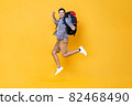 Excited young Caucasian male tourist backpacker jumping in mid-air  82468490