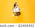 Energenic beautiful Asian woman tourist with luggage jumping in mid-air 82468492