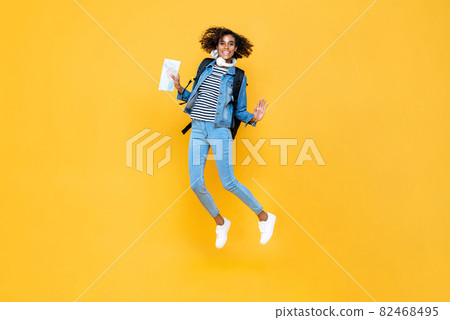Happy energetic smiling young woman tourist holding map jumping 82468495