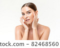 Beautiful Caucasian woman with clear fresh glowing skin touching her face for skincare concepts 82468560