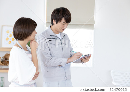 一個穿著工作服的男人和一位家庭主婦一起諮詢房屋改造 82470013