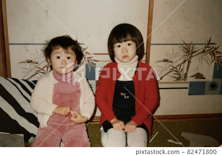 1975年的兩個親密的姐妹並排坐著 82471800