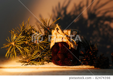 Pine jam in a glass jar. This healthy delicacy is prepared at home and stored. Pine jam in a glass jar. This healthy delicacy is prepared at home and stored. 82474398