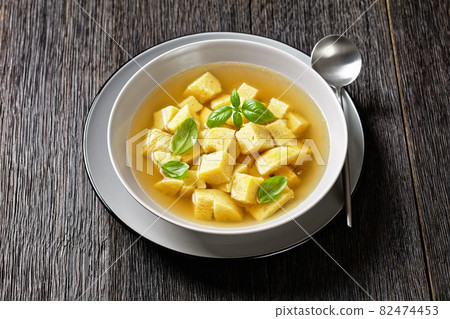 soup of chicken broth with parmesan egg dumplings 82474453