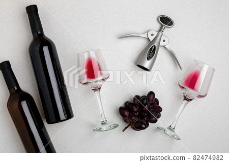 Glasses and bottles of red and white wine on white background from top view 82474982