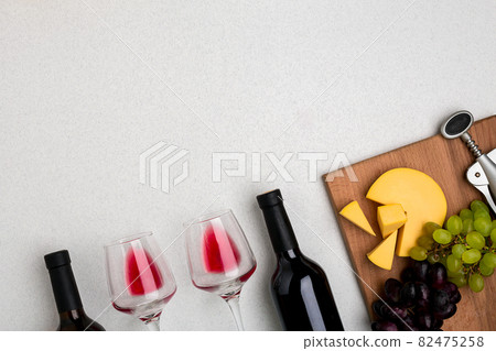 Glasses and bottles of red and white wine on white background from top view 82475258