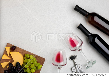 Two glasses of red wine, cheese and grapes. Top view Two glasses of red wine, cheese and grapes. Top view 82475974