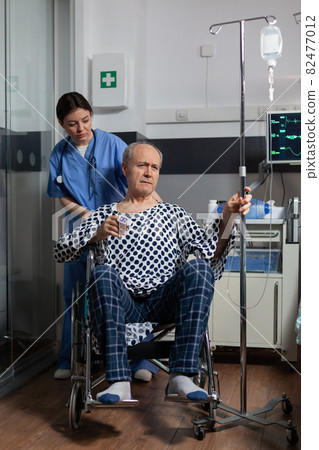 Hospitalized senior man sitting in wheelchair in hospital room Hospitalized senior man sitting in wheelchair in hospital room 82477012