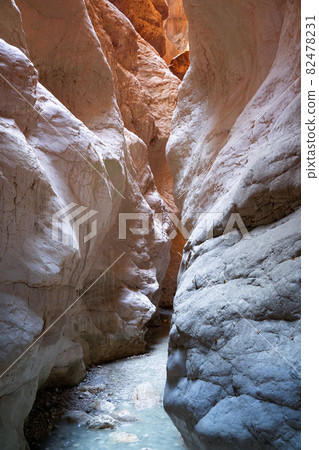 vertical canyon entrance with light shining on rocks 82478231