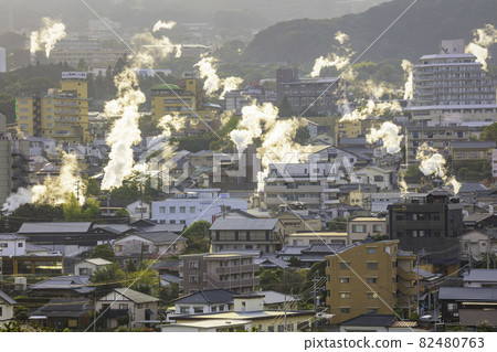 Scenery of Kannawa Onsen town with beautiful steam shining in the setting sun (Beppu City, Oita Prefecture) 82480763