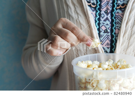 young women eating popcorn close up young women eating popcorn close up 82480940