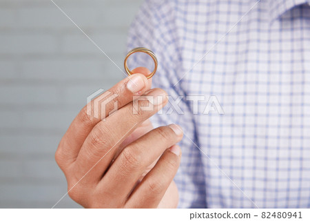 young man hold a wedding ring with copy space young man hold a wedding ring with copy space 82480941