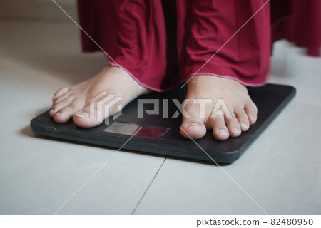 woman's feet on weight scale close up. woman's feet on weight scale close up. 82480950