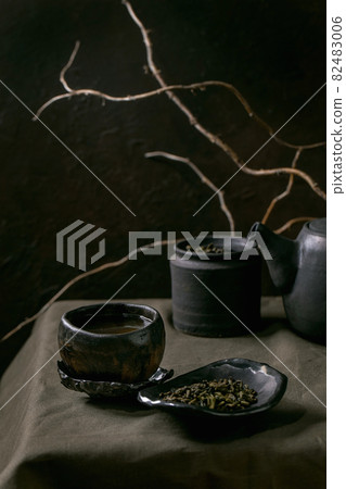 Set of craft handmade ceramic teapot and cups with dark background 82483006