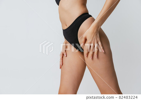 Beautiful fitness female body, legs isolated on gray studio background. Natural beauty, spa, anti-cellulite treatments concept. 82483224