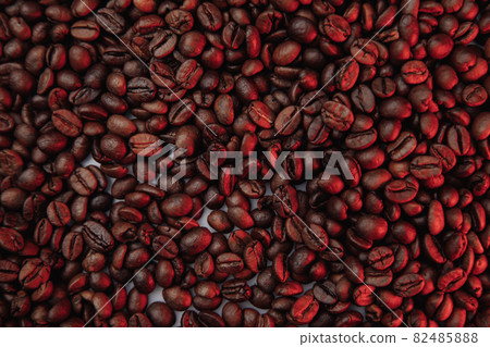 Roasted coffee beans background in red color close-up 82485888