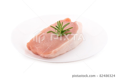 Raw pork in white plate on dark background 82486324