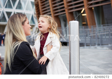 Young woman takes care of her crying daughter Young woman takes care of her crying daughter 82489272