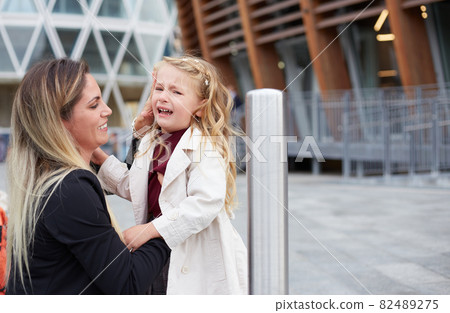 Young woman takes care of her crying daughter 82489275