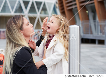Young woman takes care of her crying daughter Young woman takes care of her crying daughter 82489276