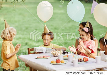 Children Enjoying Birthday Party in Summer Children Enjoying Birthday Party in Summer 82489303