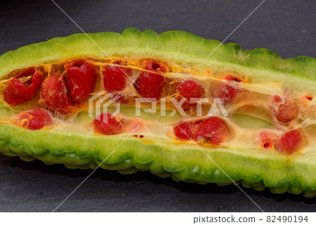 Cross-section cut of harvested bitter gourd and ripe seeds 82490194