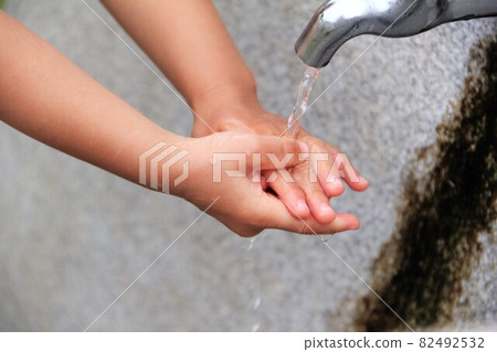 Hands of a child washing hands with a tap Hands of a child washing hands with a tap 82492532