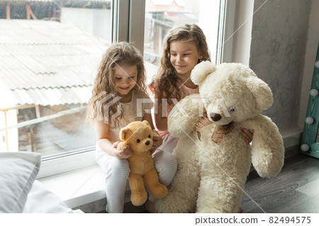 A beautiful girls with Teddy bear, a child with toy. The concept of childhood, morning pastime A beautiful girls with Teddy bear, a child with toy. The concept of childhood, morning pastime 82494575