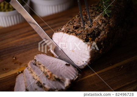 slieced roasted pork on wooden cutting board 82496728