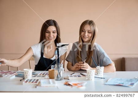 Front view of four beautiful caucasian female at art workshop. A young teacher teaches drawing Front view of four beautiful caucasian female at art workshop. A young teacher teaches drawing 82499767
