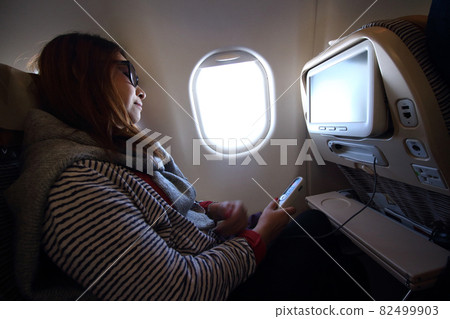 woman travel by plane , inside airplane economy class woman travel by plane , inside airplane economy class 82499903