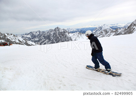 Snow covered mountain peak winter and snowboard 82499905