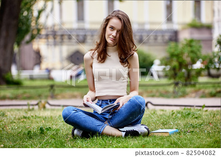 European student is reading book in public park. European student is reading book in public park. 82504082