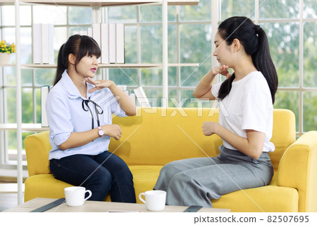 Young and beautiful Asain woman learning hand sign, deaf language from the instructor. 82507695