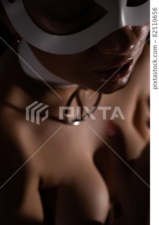 Woman in mask touching breast Woman in mask touching breast 82510656