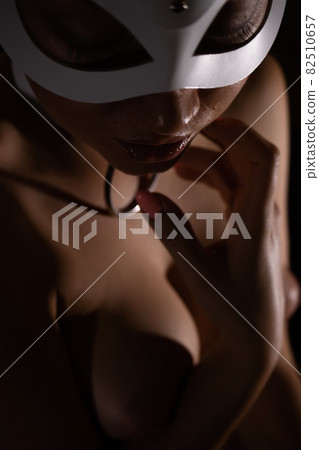 Woman in mask touching breast Woman in mask touching breast 82510657