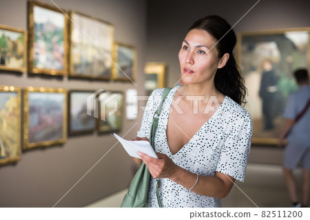 woman admiring art work woman admiring art work 82511200