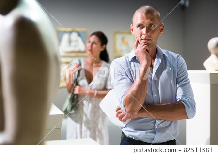 Man standing in museum hall Man standing in museum hall 82511381